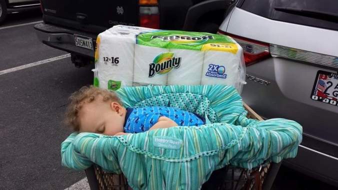 The author's son asleep in a grocery cart